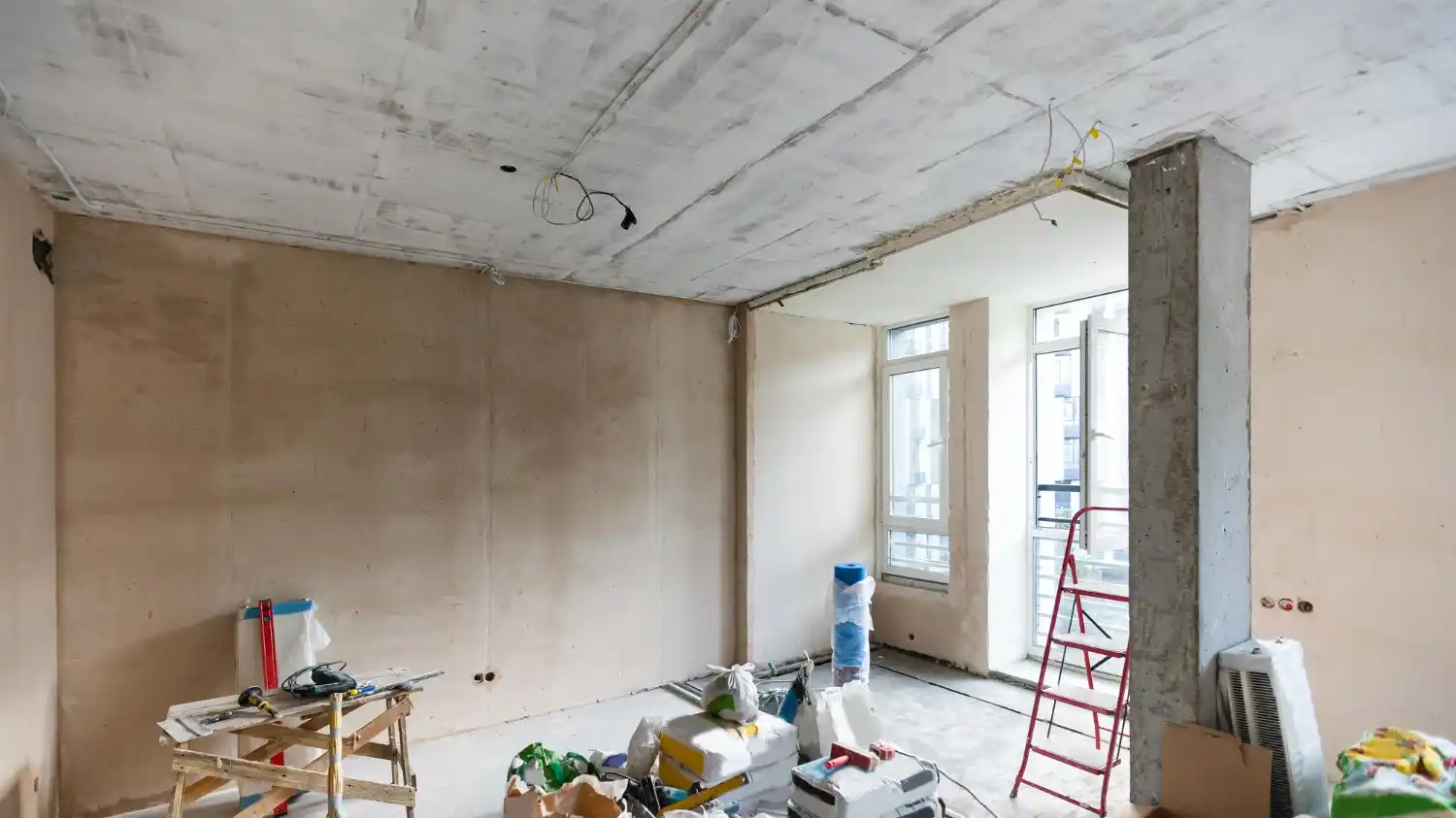 Contractors installing drywall and ceiling systems in a remodeled basement